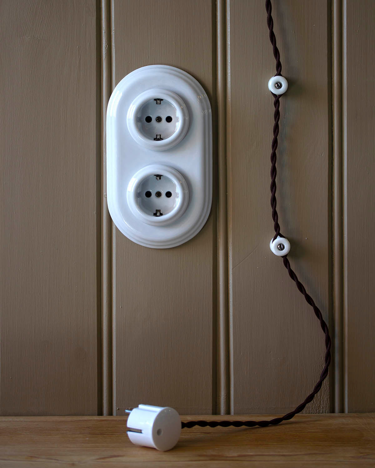 Facts & Info - Porcelain insulators, intertwined cable and light fixtures card image